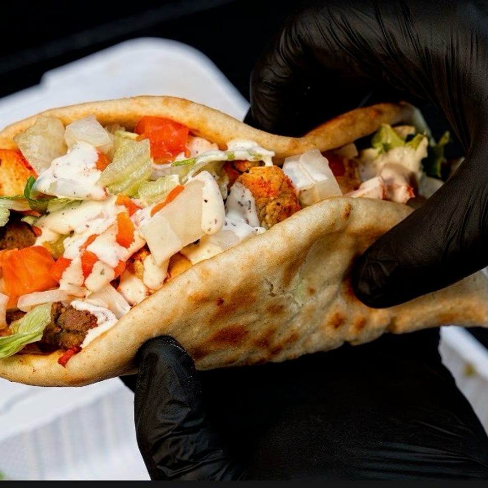 Falafel wrapped in warm pita with lettuce, tomato, onion, and creamy sauces.